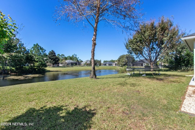 view of yard featuring a trampoline and a water view