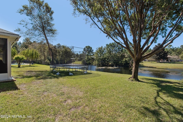 view of yard featuring a water view and a trampoline