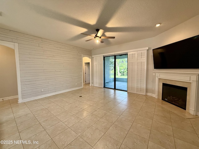 32540 Willow Parke Cir, Fernandina Beach, FL 32034 - unfurnished living room featuring light tile patterned floors, a ceiling fan, a textured ceiling, baseboards, and a fireplace