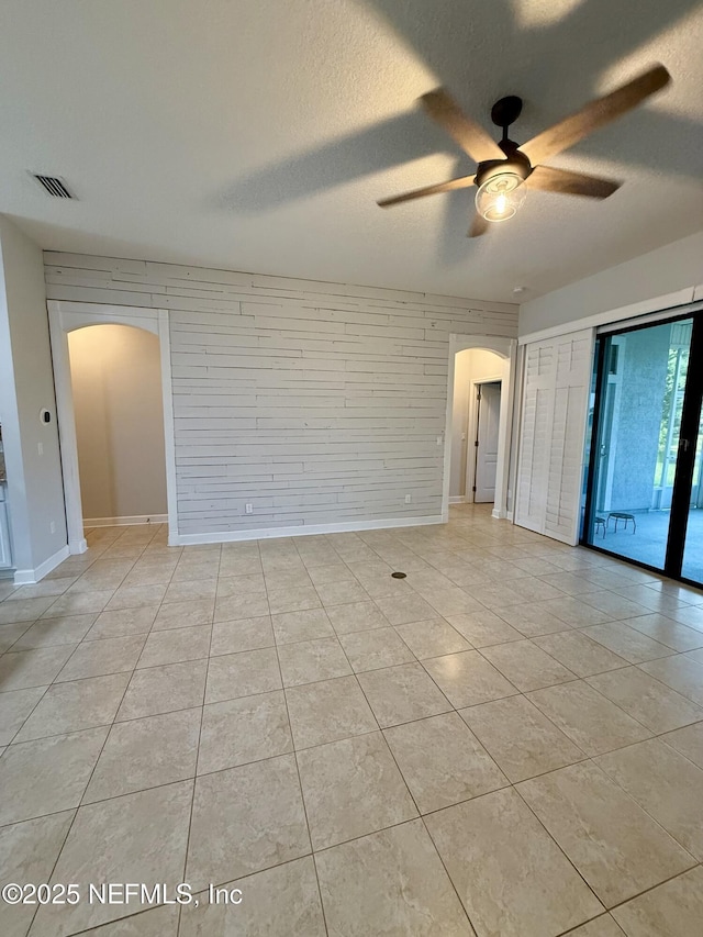 32540 Willow Parke Cir, Fernandina Beach, FL 32034 - unfurnished room with arched walkways, a ceiling fan, a textured ceiling, and light tile patterned floors