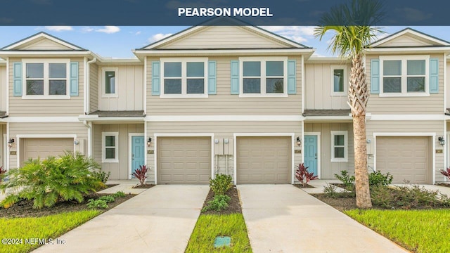 view of property featuring board and batten siding, concrete driveway, and an attached garage