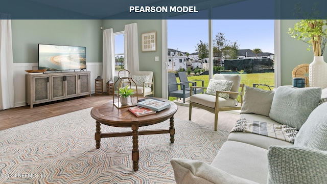 living room with wood finished floors and wainscoting