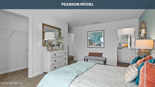 carpeted bedroom with a spacious closet, baseboards, and ensuite bathroom