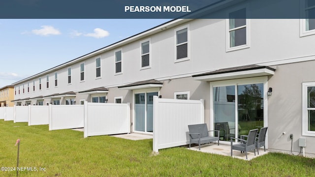 back of house featuring a lawn and a patio