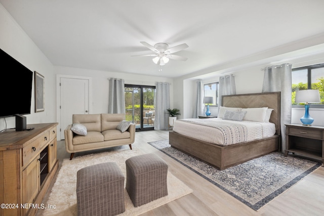 bedroom with ceiling fan, multiple windows, light wood-type flooring, and access to exterior