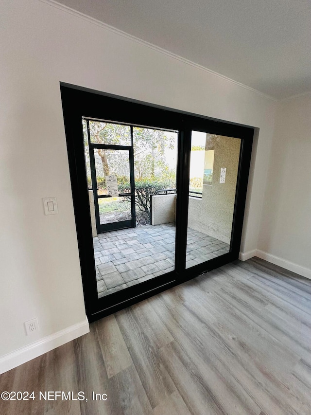 entryway with light hardwood / wood-style floors and ornamental molding