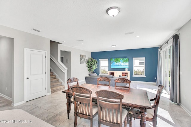 dining area with light tile patterned floors and a textured ceiling