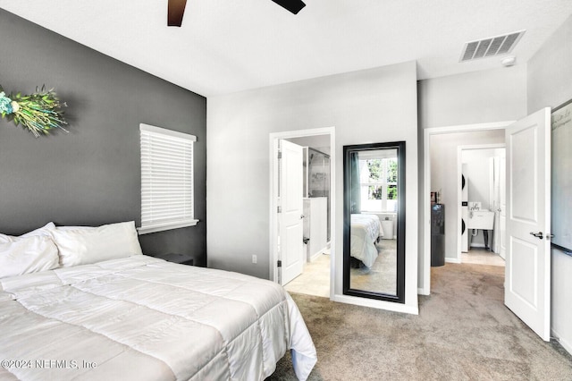 bedroom with ceiling fan, light carpet, and connected bathroom