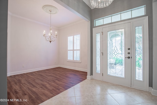 foyer featuring a notable chandelier, crown molding, and tile patterned floors