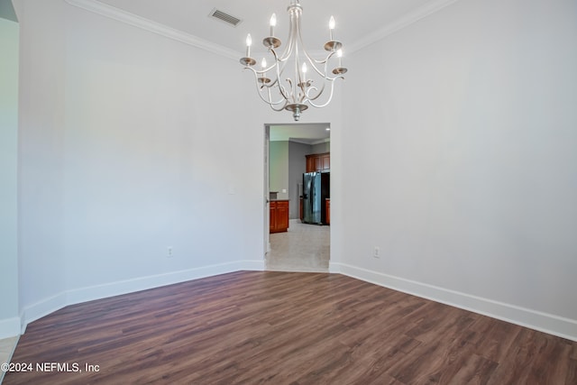 spare room with crown molding, a chandelier, and dark hardwood / wood-style flooring