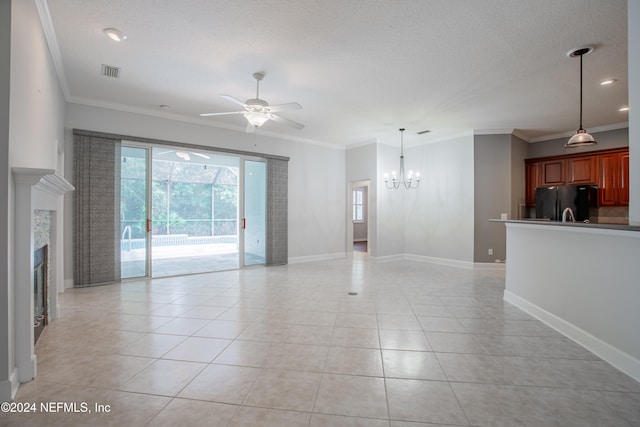 unfurnished living room with light tile patterned floors, a fireplace, ornamental molding, a textured ceiling, and ceiling fan with notable chandelier