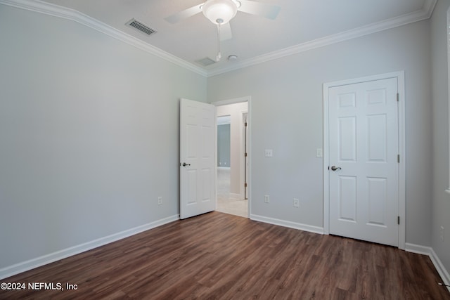 unfurnished bedroom featuring dark wood-type flooring, ornamental molding, and ceiling fan