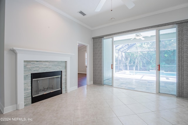 unfurnished living room featuring light tile patterned flooring, ceiling fan, ornamental molding, and a tiled fireplace