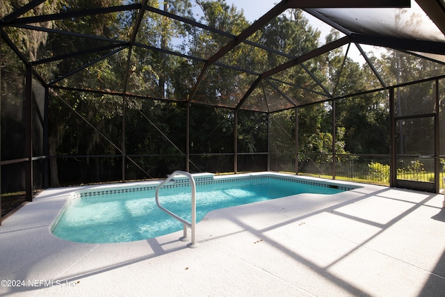 view of pool featuring glass enclosure and a patio