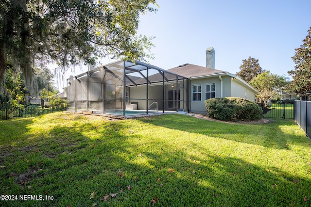 back of property with a fenced in pool, a lanai, and a lawn