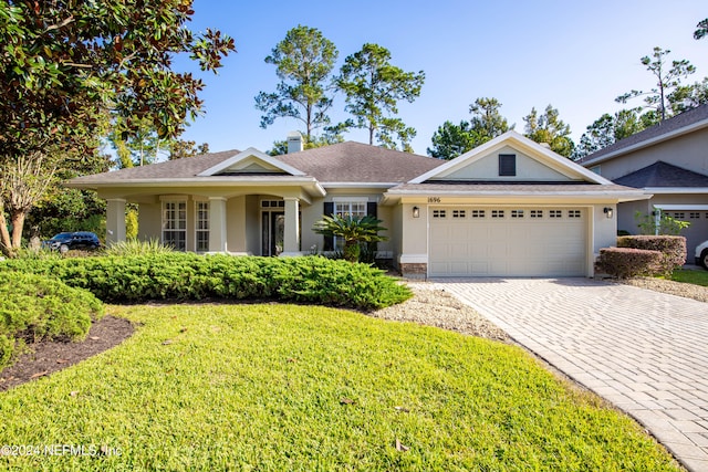 view of front of property featuring a garage and a front yard