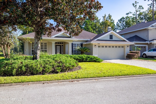 view of front of house with a garage and a front lawn