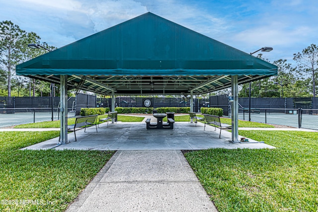 view of community with a yard and tennis court