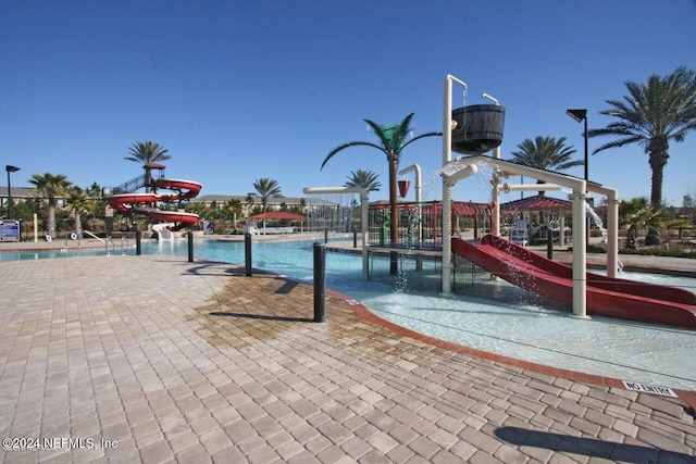 view of pool with a playground and a water slide