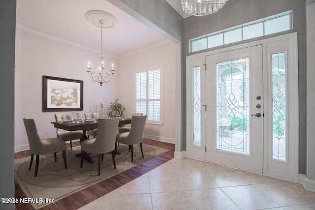 foyer featuring crown molding, light tile patterned flooring, and a notable chandelier