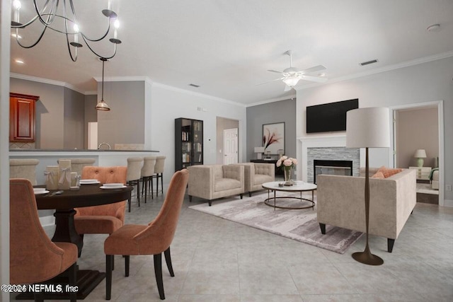 tiled living room with ornamental molding and ceiling fan with notable chandelier