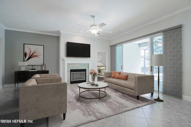 living room featuring light tile patterned flooring, ceiling fan, ornamental molding, and a textured ceiling