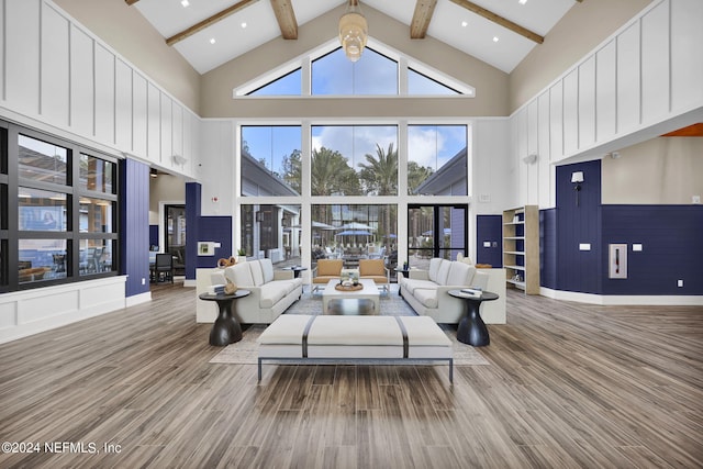 living room featuring wood-type flooring, high vaulted ceiling, and beamed ceiling