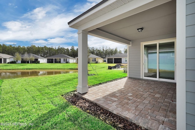 view of yard featuring a water view and a patio