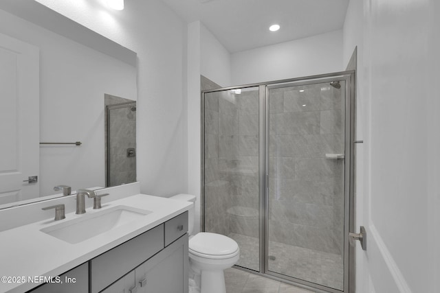 bathroom featuring vanity, a shower with shower door, tile patterned floors, and toilet