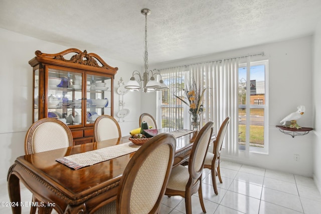 dining space with light tile patterned floors, a textured ceiling, and an inviting chandelier