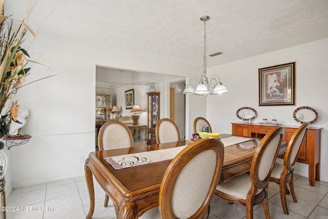 dining area featuring a chandelier and light tile patterned flooring