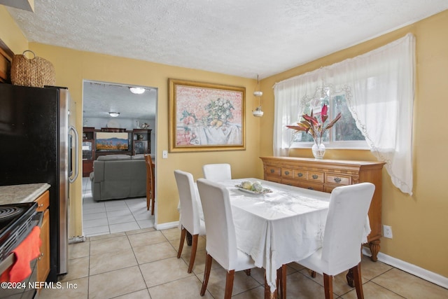 tiled dining space with a textured ceiling