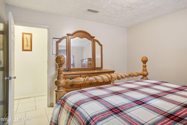 bedroom with light tile patterned floors and a textured ceiling