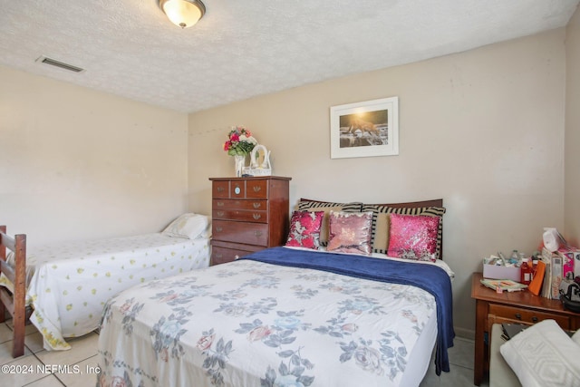 tiled bedroom featuring a textured ceiling