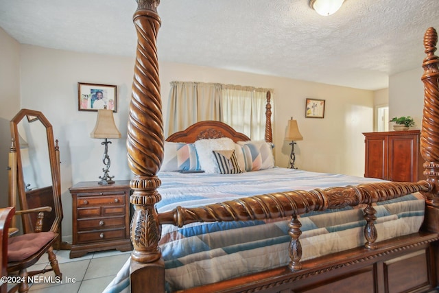 bedroom featuring light tile patterned floors and a textured ceiling