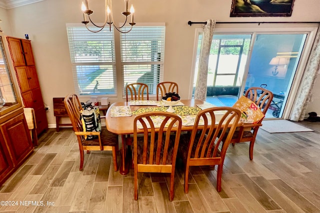 dining area featuring a wealth of natural light, ornamental molding, a chandelier, and light wood-type flooring