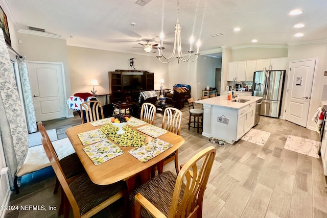 dining area with crown molding, vaulted ceiling, sink, and ceiling fan with notable chandelier