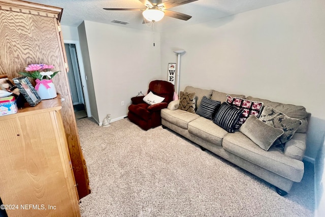 living room with a textured ceiling, carpet flooring, and ceiling fan