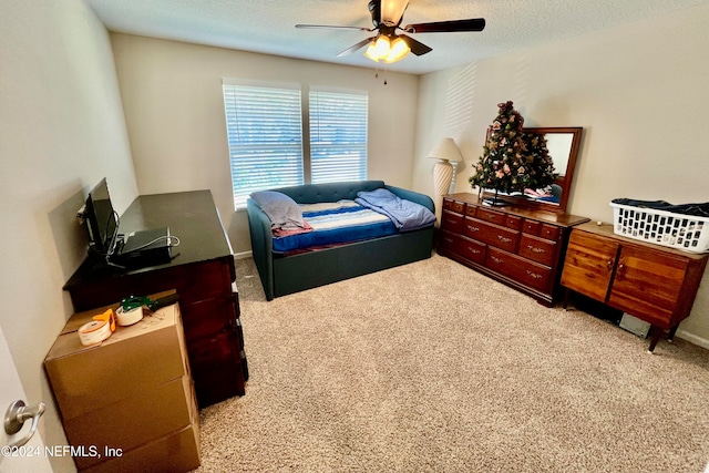 bedroom featuring light carpet, a textured ceiling, and ceiling fan