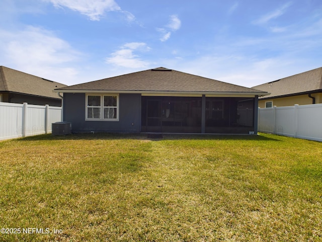 rear view of property featuring a sunroom, a fenced backyard, a yard, and roof with shingles