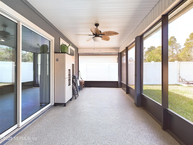 unfurnished sunroom featuring a ceiling fan