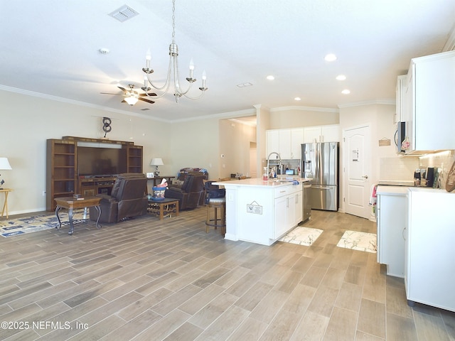 kitchen featuring visible vents, appliances with stainless steel finishes, light wood-style floors, open floor plan, and a kitchen bar