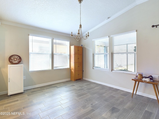 unfurnished dining area featuring a textured ceiling, ornamental molding, vaulted ceiling, and wood finished floors