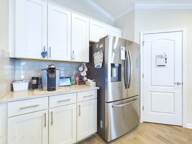 kitchen featuring decorative backsplash, white cabinets, crown molding, and stainless steel fridge with ice dispenser