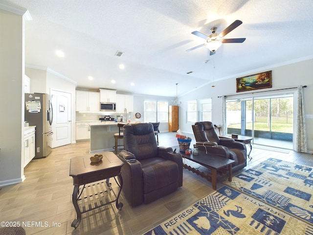 living room featuring lofted ceiling, ornamental molding, plenty of natural light, and visible vents