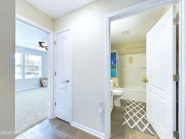 bathroom featuring shower / tub combo, baseboards, ceiling fan, and toilet