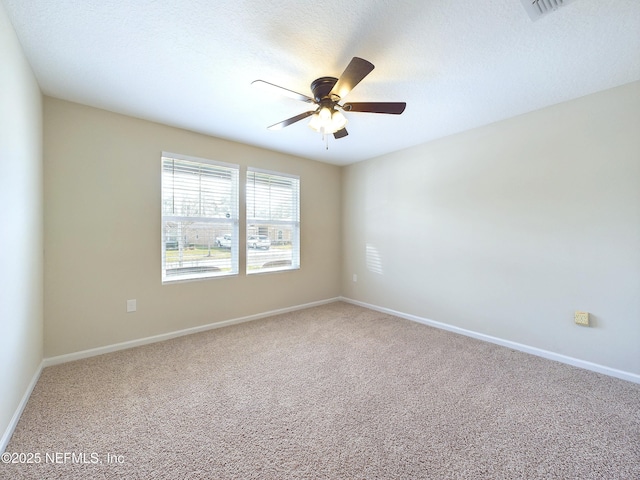 carpeted empty room featuring a ceiling fan, a textured ceiling, and baseboards