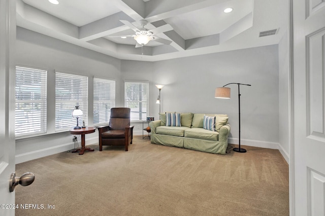 living room featuring coffered ceiling, carpet, and a healthy amount of sunlight