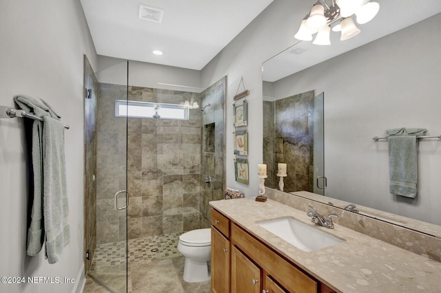 bathroom with an enclosed shower, toilet, vanity, an inviting chandelier, and tile patterned flooring