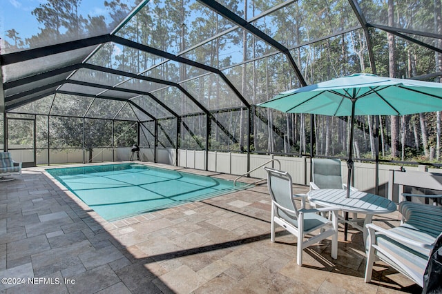 view of pool with a patio and glass enclosure